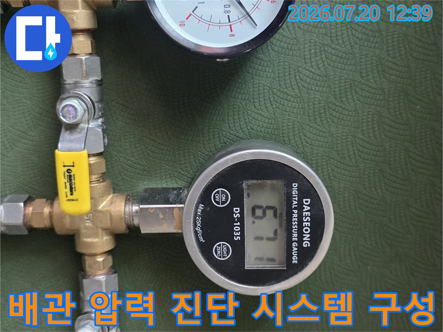 금속 배관 뭉치 위에 설치된 두 종류의 압력 게이지와 연결 호스