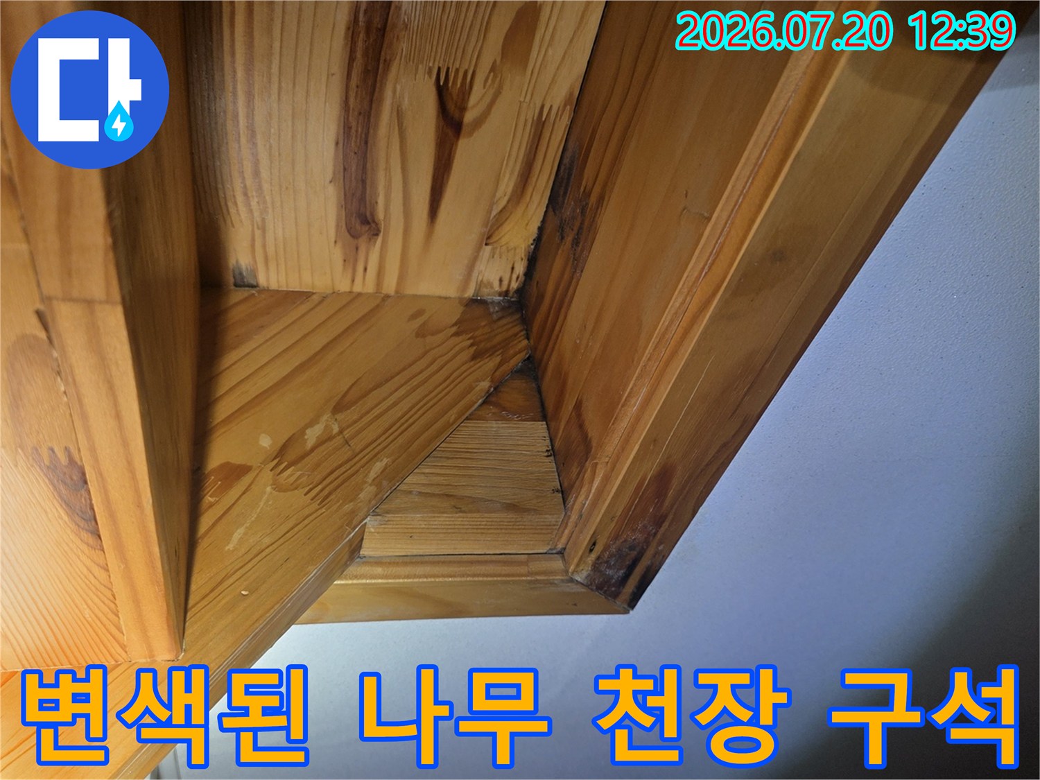 나무 프레임 접합부에 수분 침투로 인해 어둡게 변한 누수 오염 부위 사진