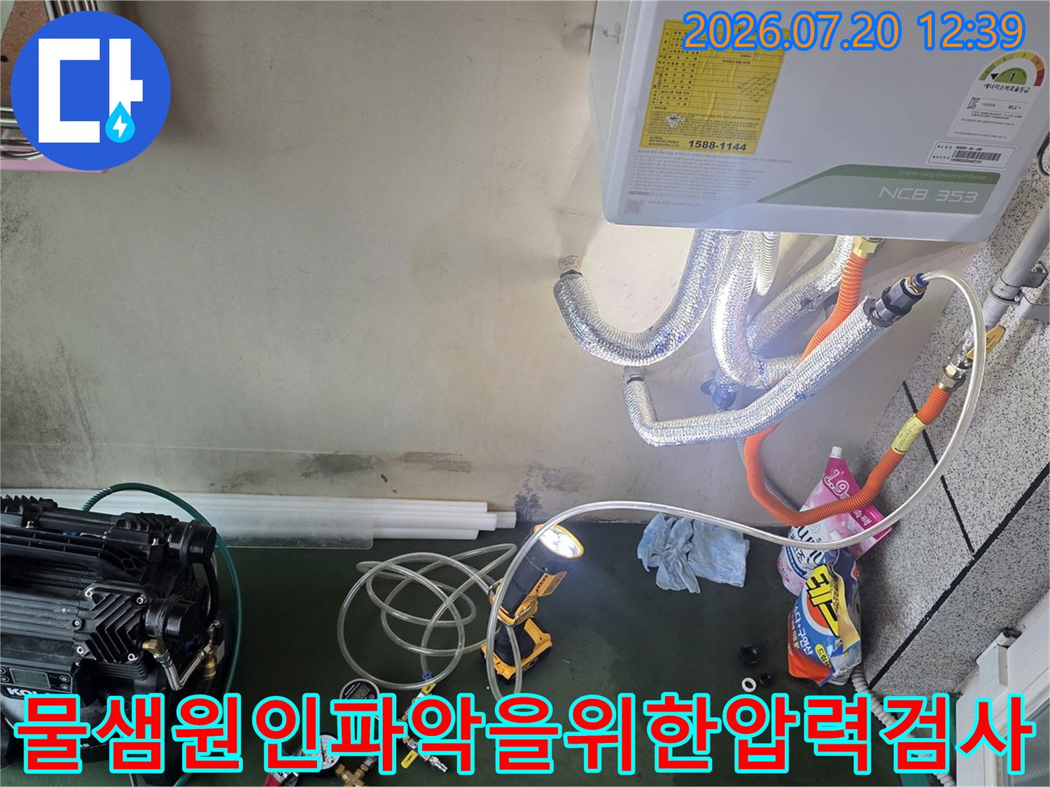 흰색 보일러 아래쪽으로 연결된 다양한 색상의 호스와 측정 장비-누수 진단 중