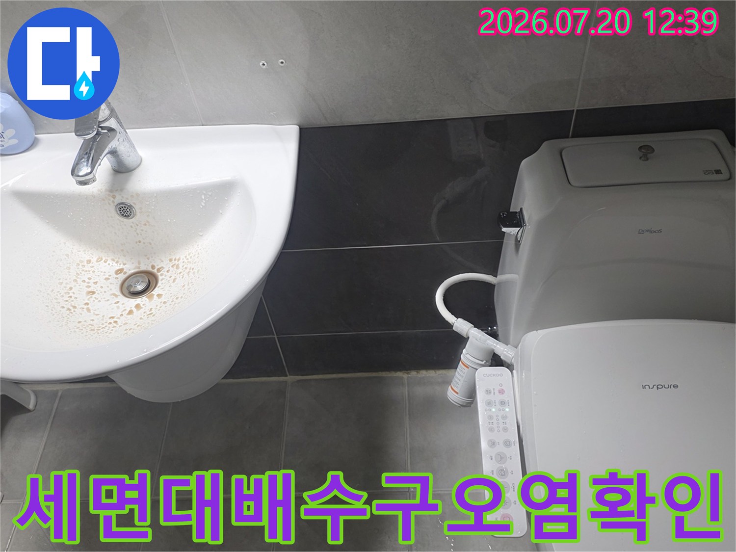 흰색-세면대의 배수구 주변 갈색 얼룩과-그 옆의 비데 설치 변기 모습