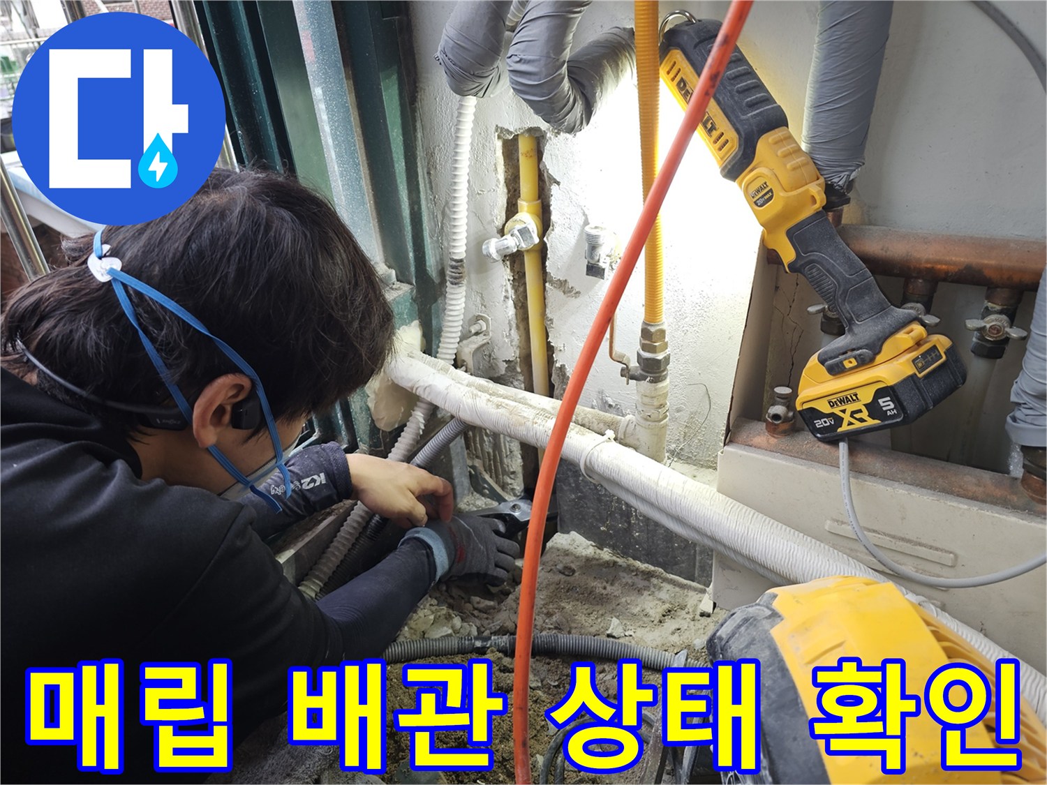 굴착된 벽면 사이로-노란색 급수 배관의 연결 상태를 점검하고 있습니다.