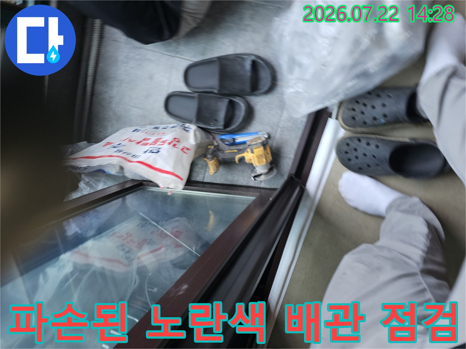 먼지가 쌓인 작업 현장에서 파손된 노란색 직수 배관을 확인하는 장면