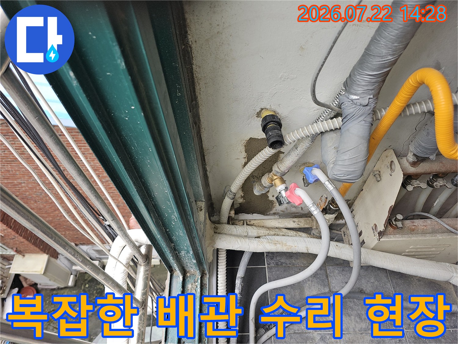 벽체에 설치된 노란색 직수관과 여러 가닥의 배관이 얽힌 모습