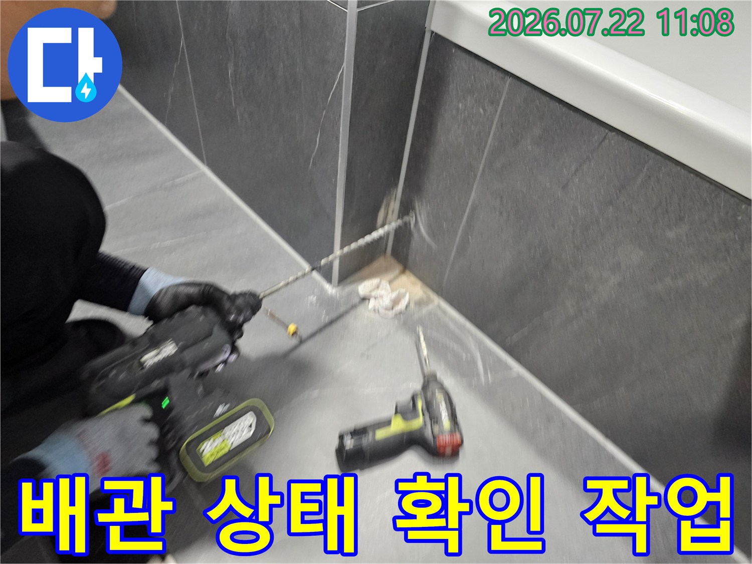 필로티 구조 건물의 천장에서 전문 드릴을 사용하여 누수 지점을 정밀하게 타공하는 엔지니어