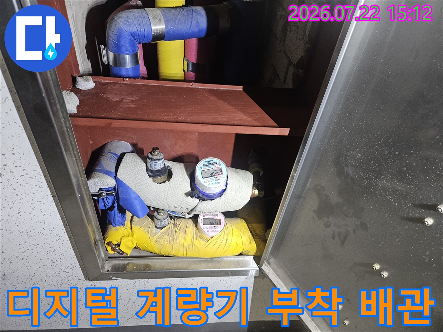 노란색 보온재와 흰색 보온재가 교차하는 지점에 설치된 수도 계량기
