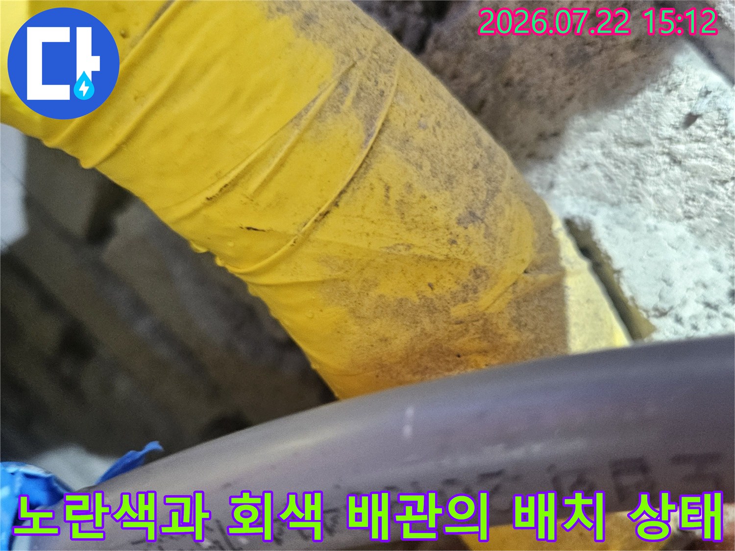 천장에 설치된 노란색 보온재 마감 배관과 회색 배관이 나란히 있는 모습-누수 진단 사진