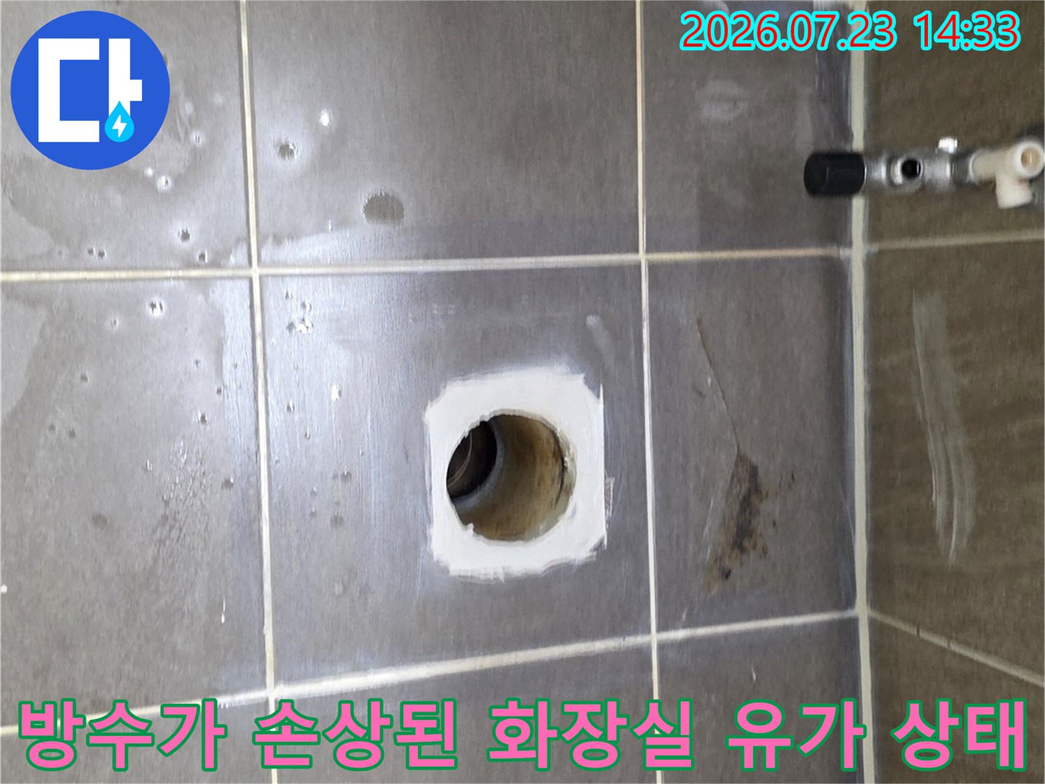회색빛 욕실 타일 중앙에 위치한 배수구-하수관 입구 주변의 누수 징후