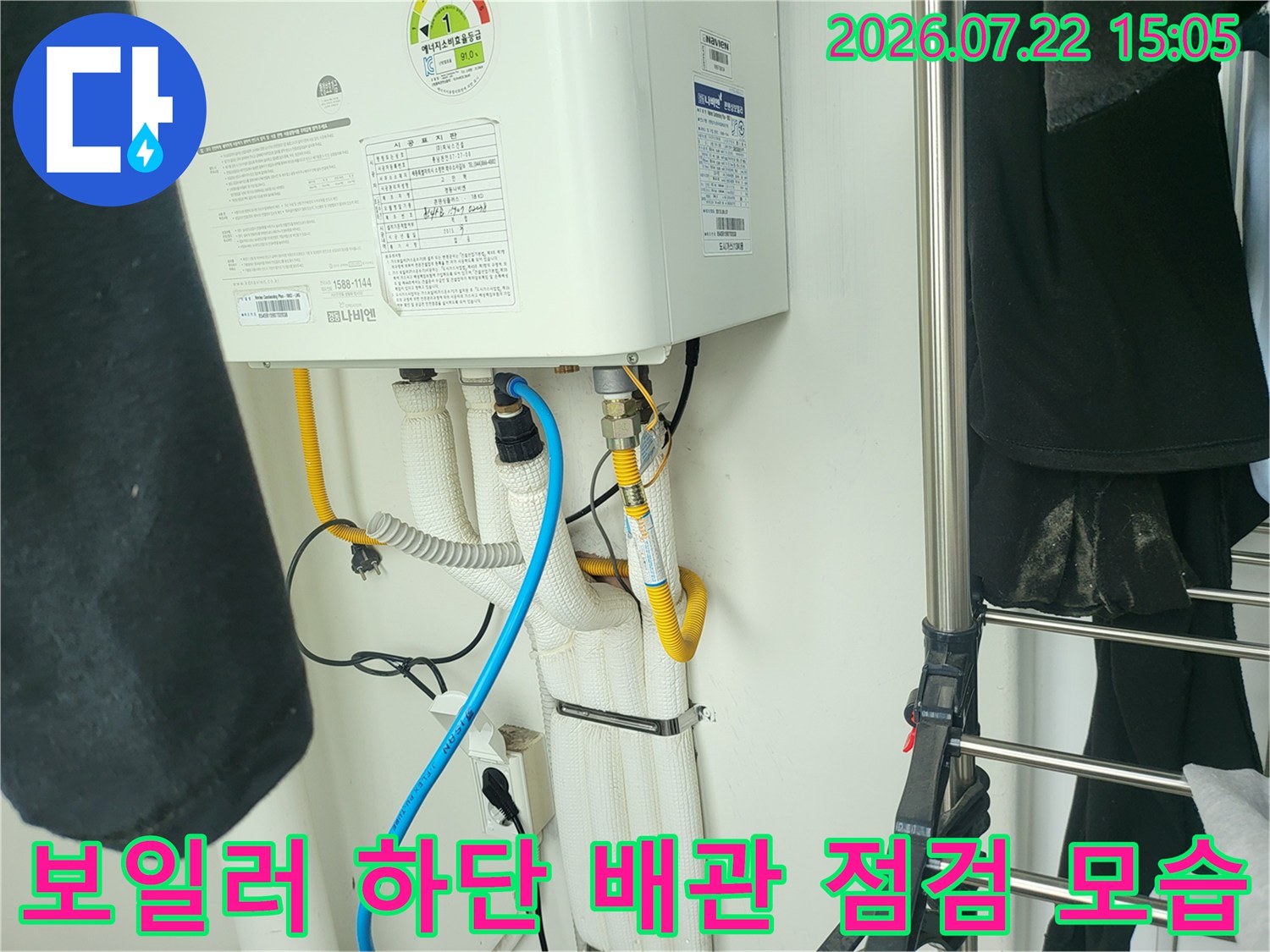 흰색 보온재로 감싸진 보일러 하단 배관과 파란색 탐지 장비 호스가 연결된 모습