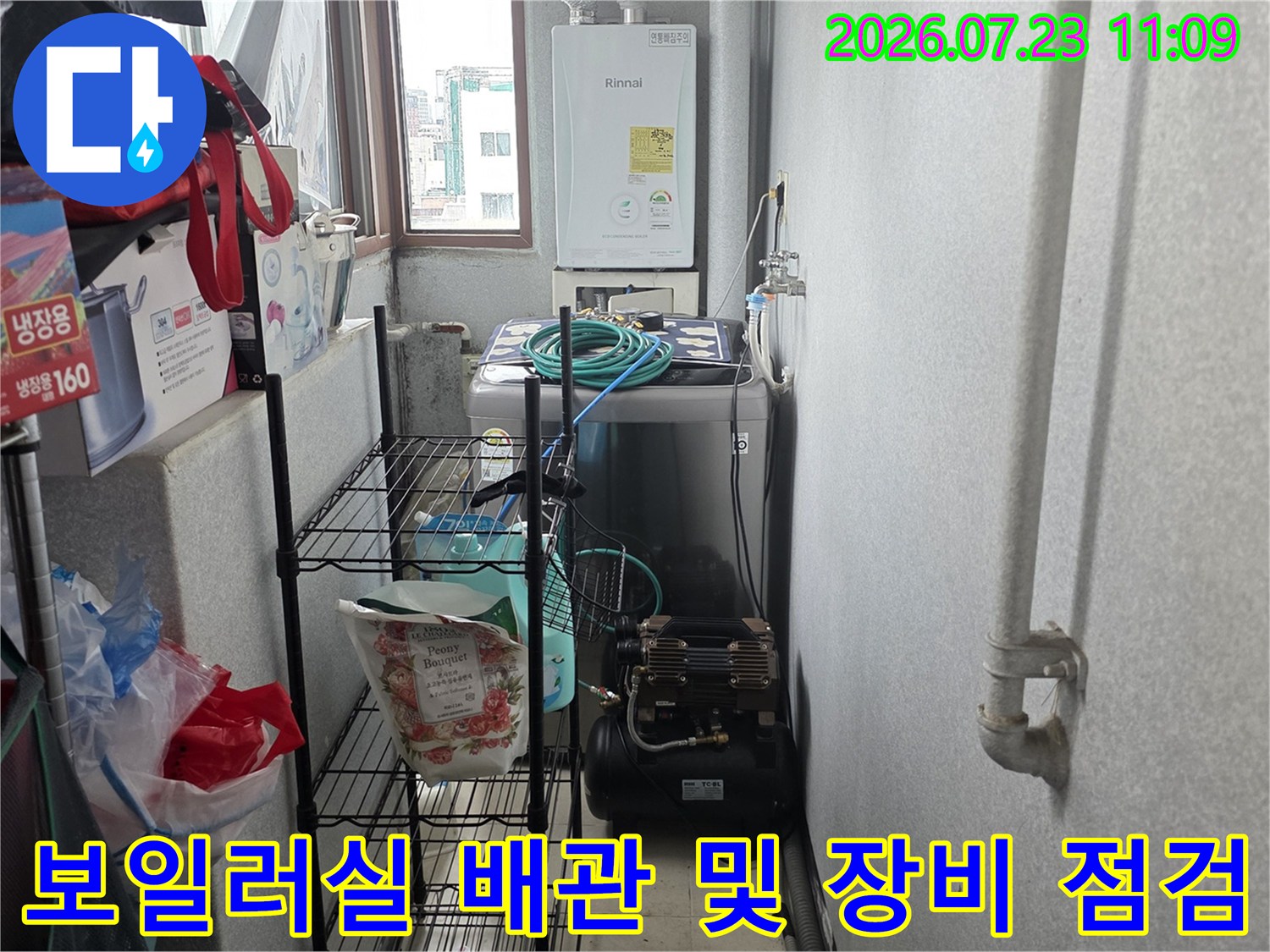 보일러실 내부에 설치된 보일러와 바닥에 놓인 누수 탐지용 공압 장비-배관 상태 확인 중