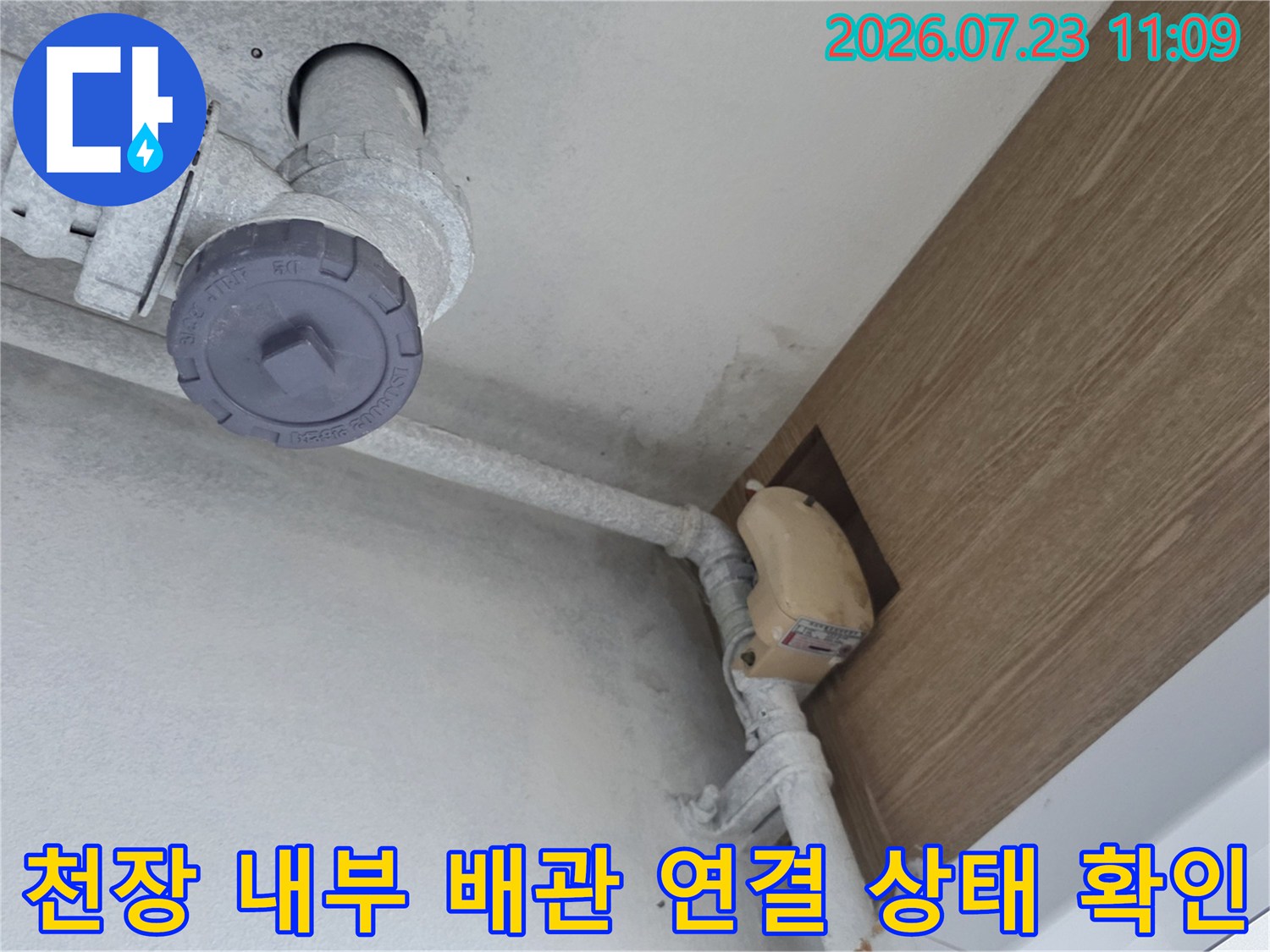 흰색 천장 바탕에 설치된 회색 배관과 점검구가 보이는 누수 진단 현장 사진