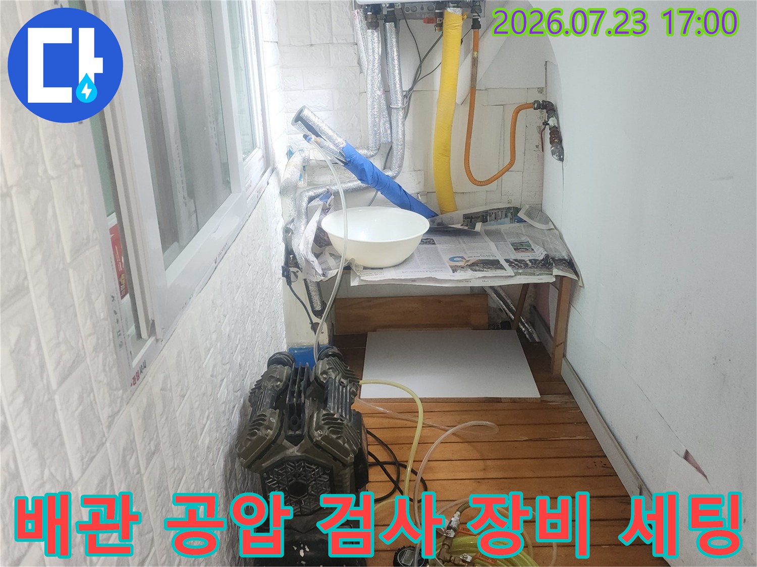 누수 탐지를 위해 배관에 연결된 공압 검사 장비와 컴프레셔-기계 설비 모습