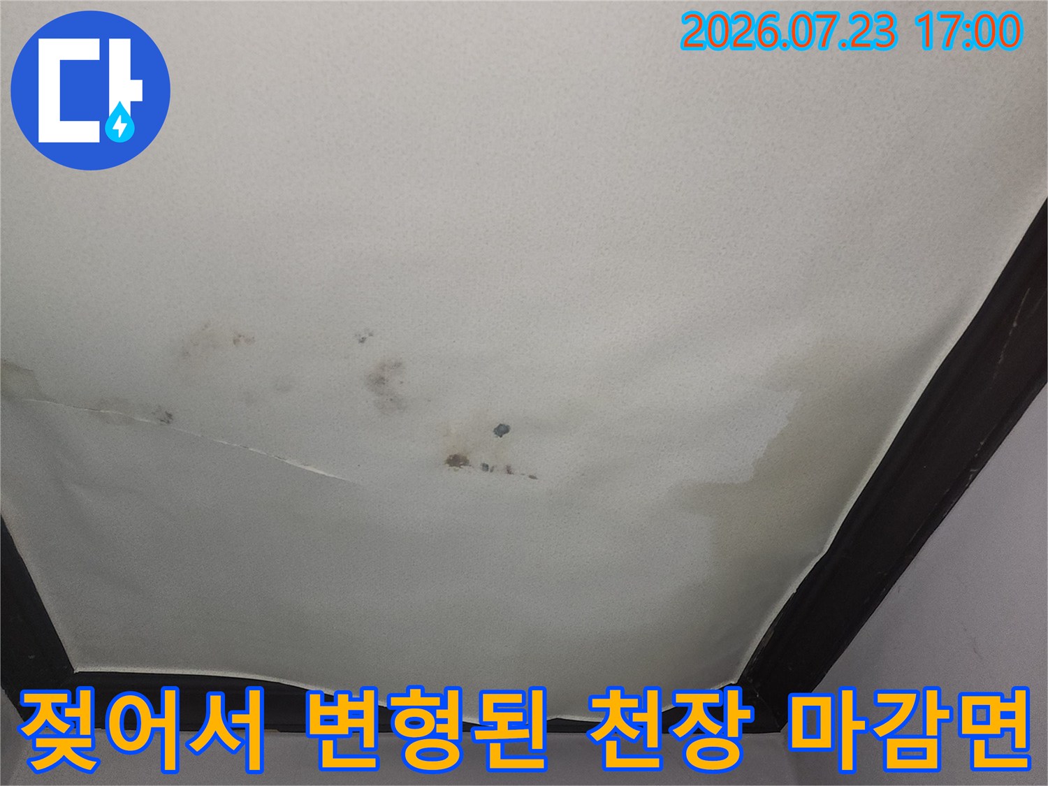 천장 벽지가 누수로 인해 노랗게 물들고 아래로 처진 상태의 사진