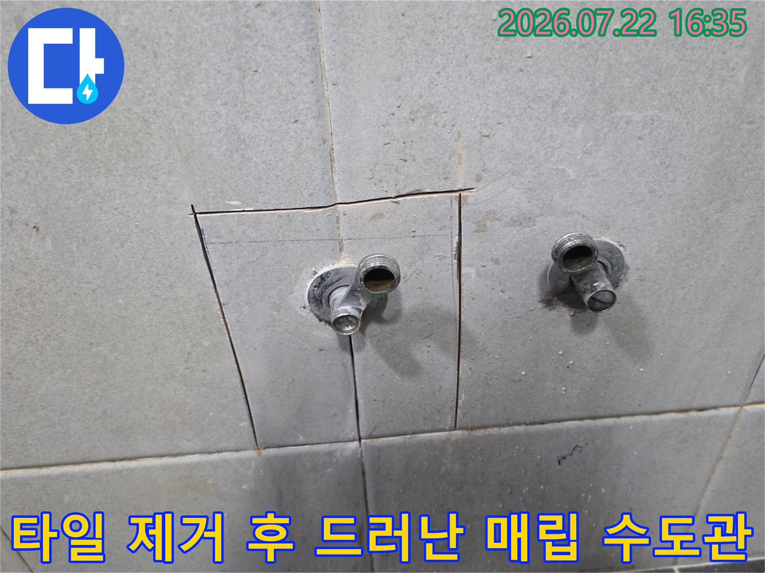 두 개의 수도 밸브가 설치된 벽면 타일을 사각형 모양으로 절개하여 내부 배관을 노출한 사진