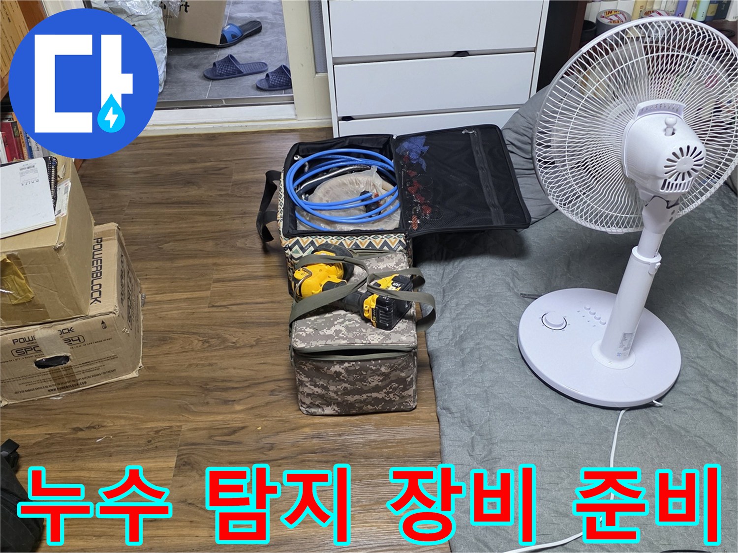 바닥에 펼쳐진 누수 점검용 호스와 공구 상자