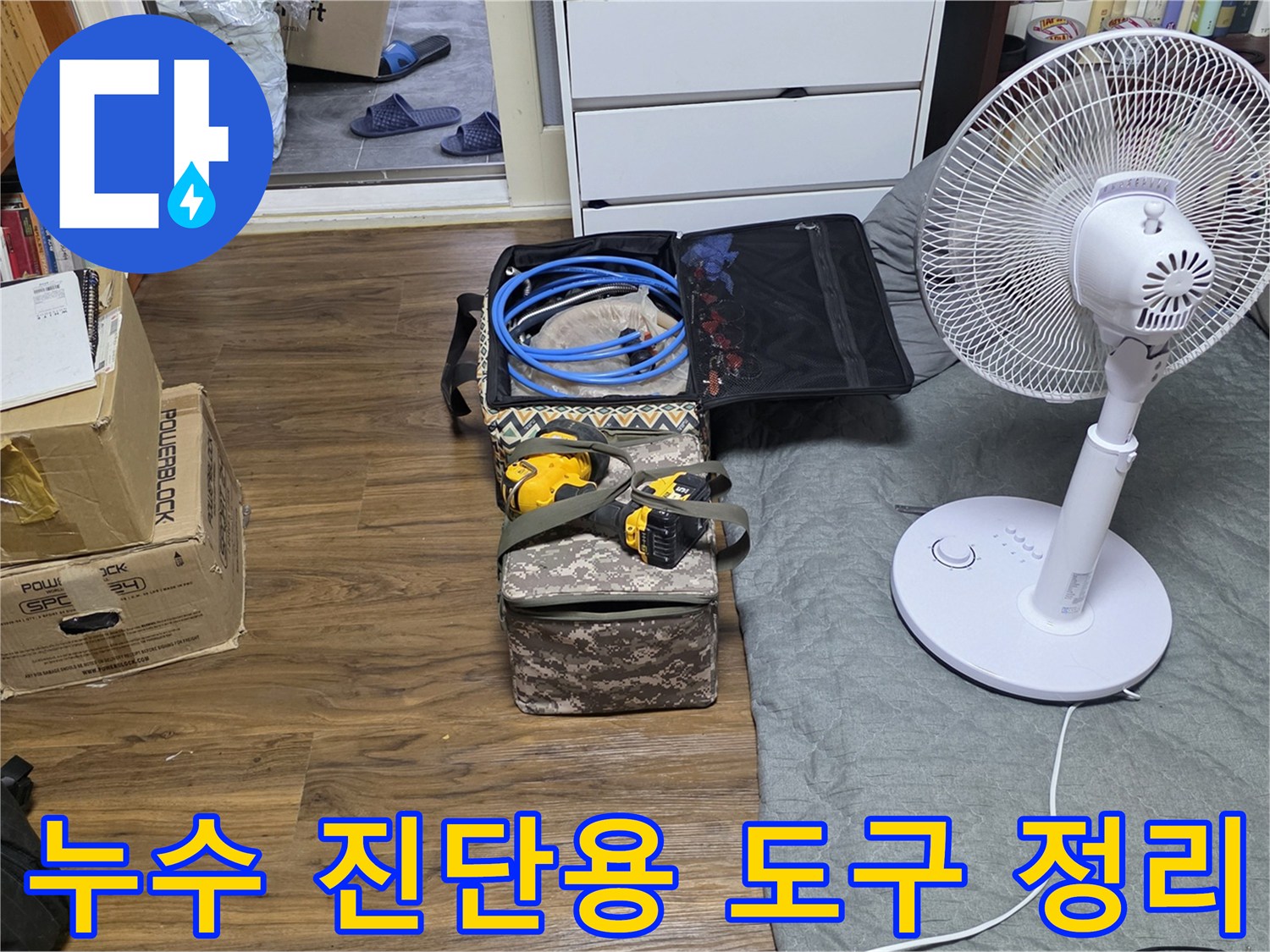 작업을 위해 바닥에 준비된 파란 호스와 수리 공구 가방