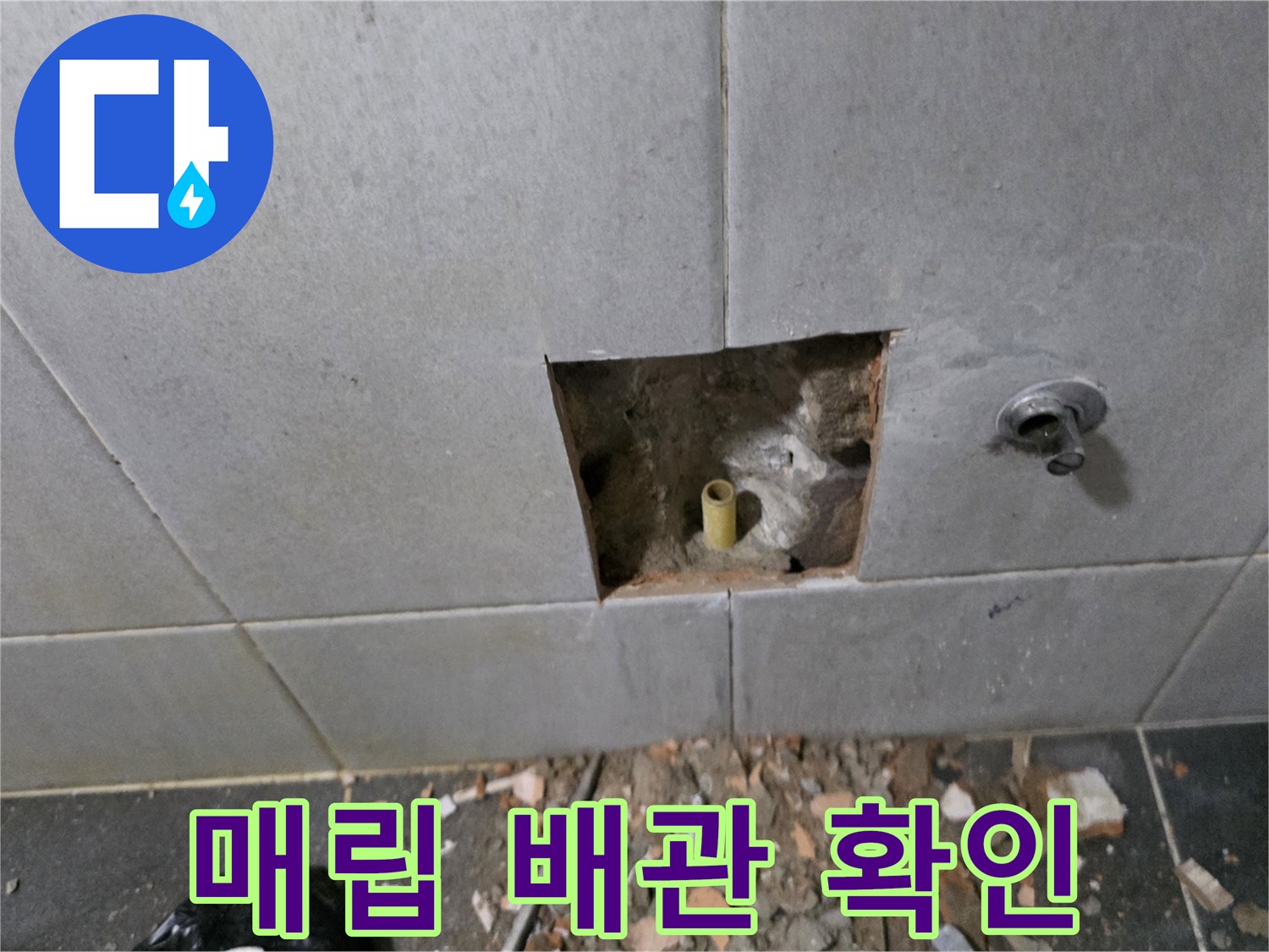 타일 틈새로 드러난 노란색 PPC 배관과 주변 흙 부위