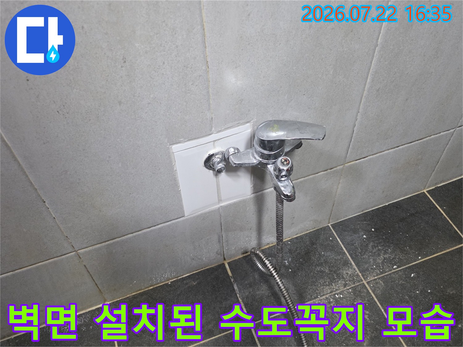 흰색 타일 벽면에 설치된 은색 수도꼭지와 연결된 샤워 호스