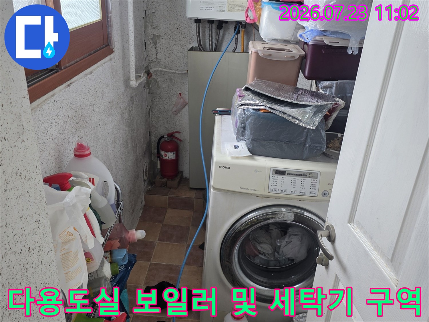 보일러와 세탁기가 설치된 좁은 다용도실-바닥 타일과 배관 모습