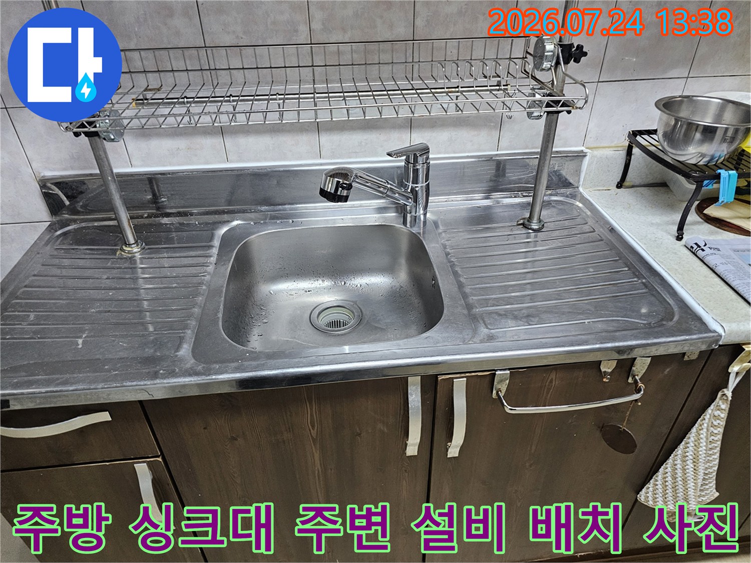 금속제 식기 건조대가 설치된 주방-싱크대 볼과 수전이 포함된 전경