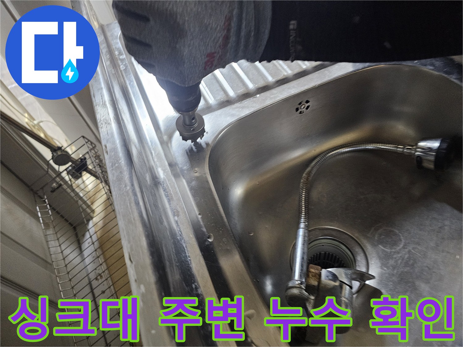 드릴을 사용하여 싱크대 옆 바닥 틈새를 파고 들어가는 작업 장면