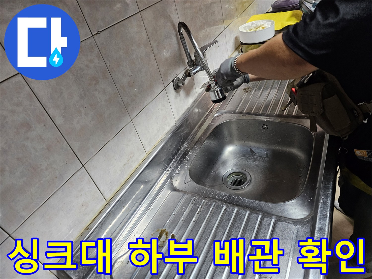 싱크대 수전 아래 배관의 이상 유무를 점검하는 모습