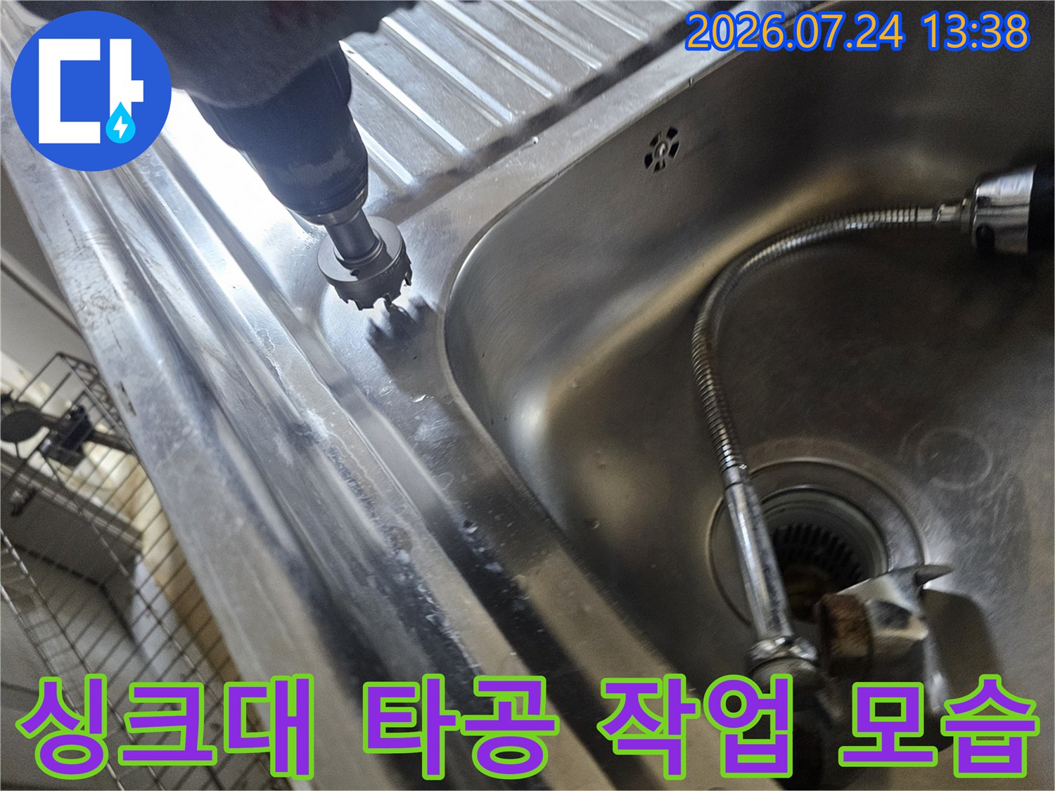 주방 싱크대 스테인리스 상판을 전동 드릴로 타공하고 있는 모습