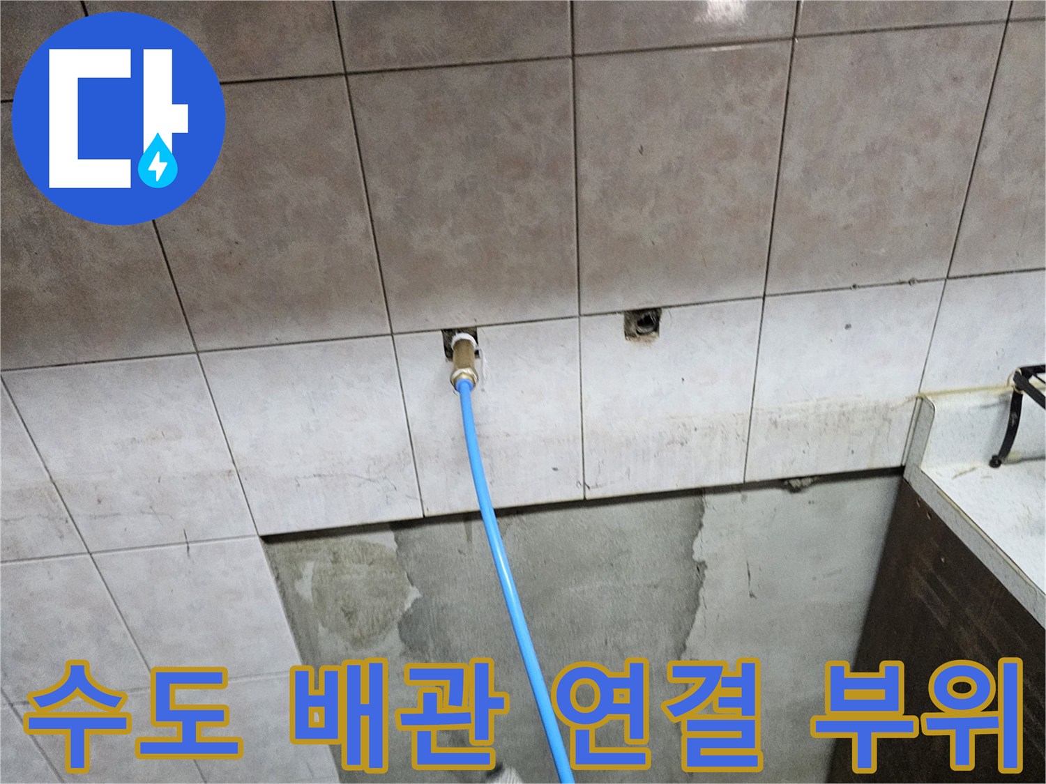 타일 벽체에서-나온 배관에 파란색 호스 연결