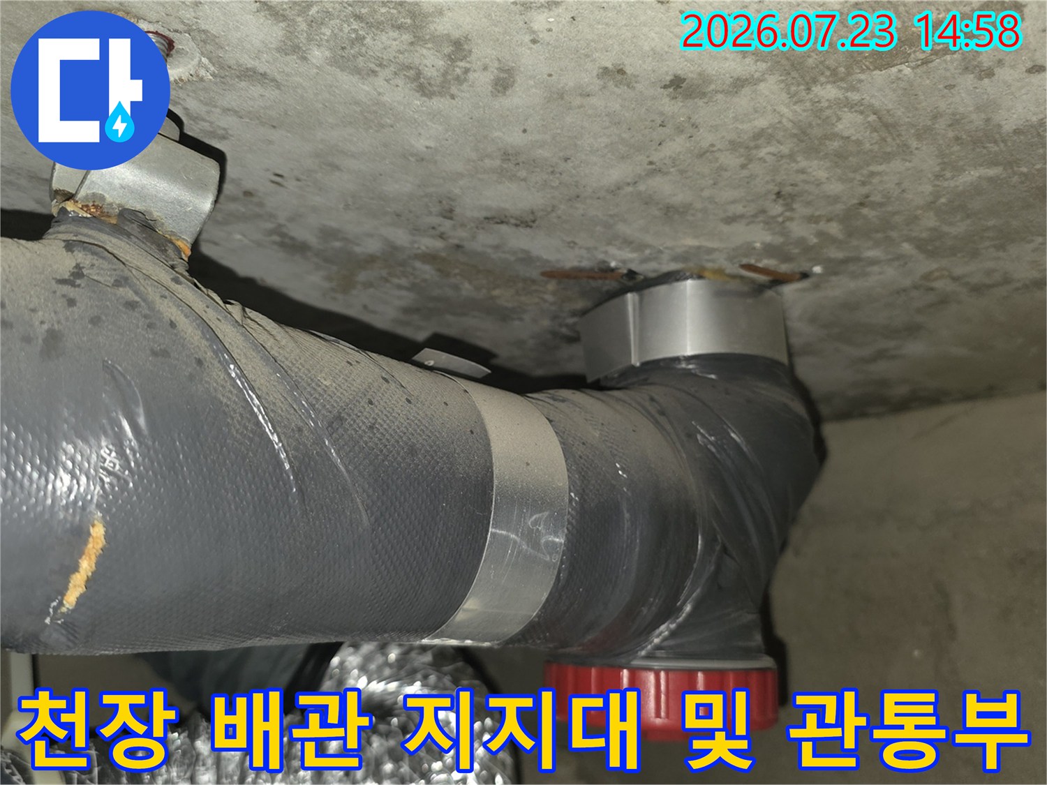 금속제 고정 핀으로 천장에 고정된 회색 배관-설치상태