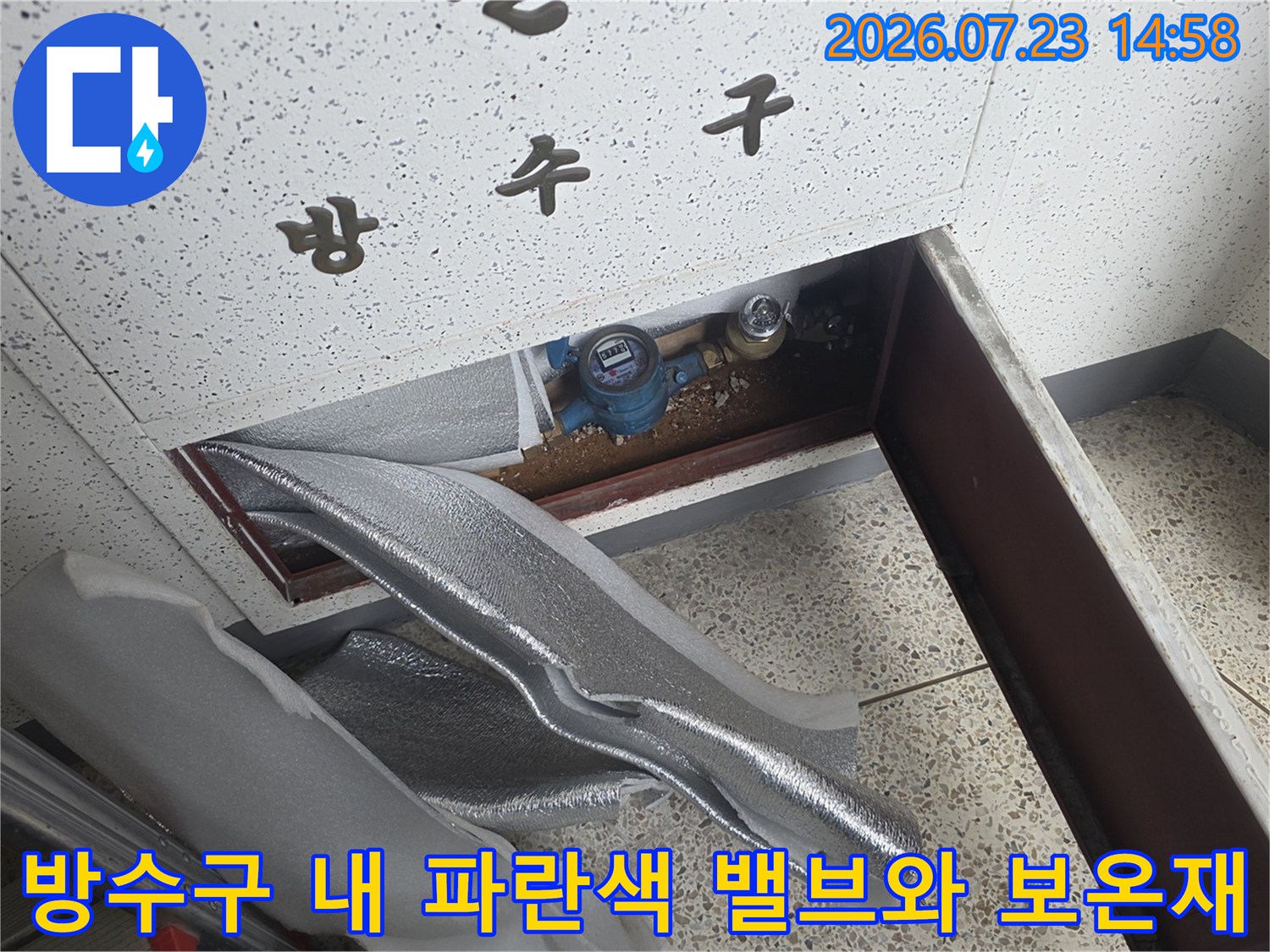 은색-보온재로-덮인-배관과-파란색-핸들-밸브가-노출된-방수구-내부