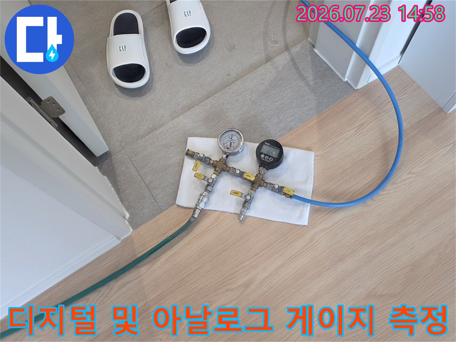 파란색 고압 호스와 압력 게이지가 연결되어 바닥에서 수치를 측정하고 있는 현장 사진