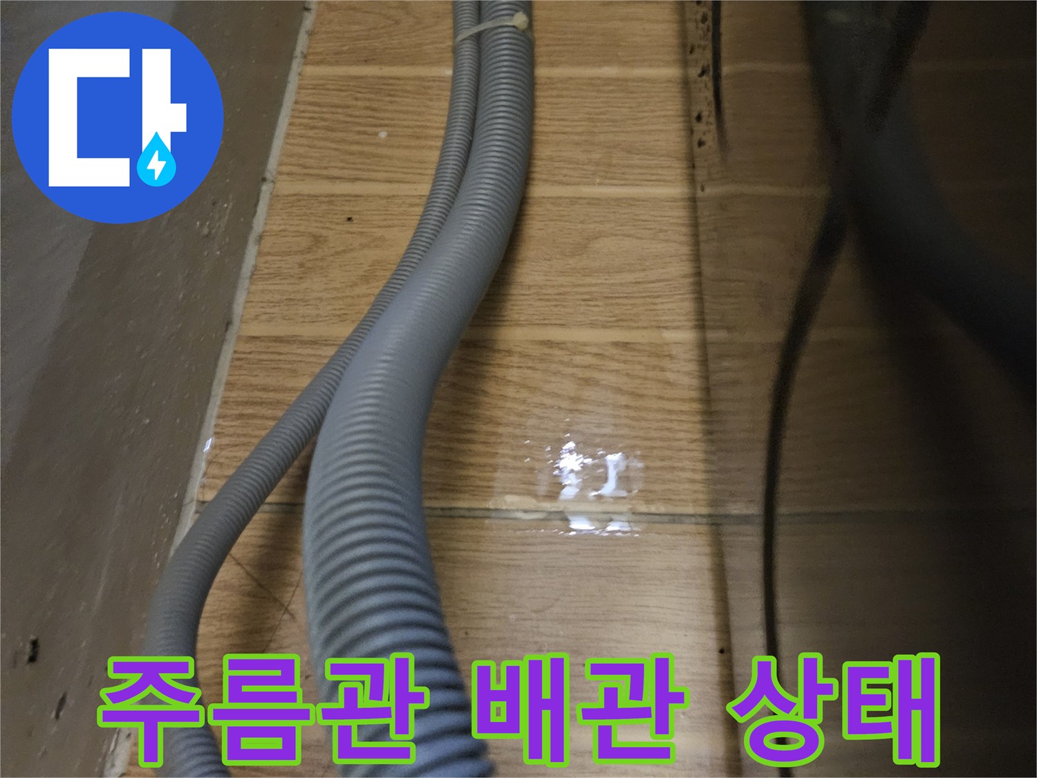 굴곡진-형태의-회색-배수-호스와-벽면-타일-모습