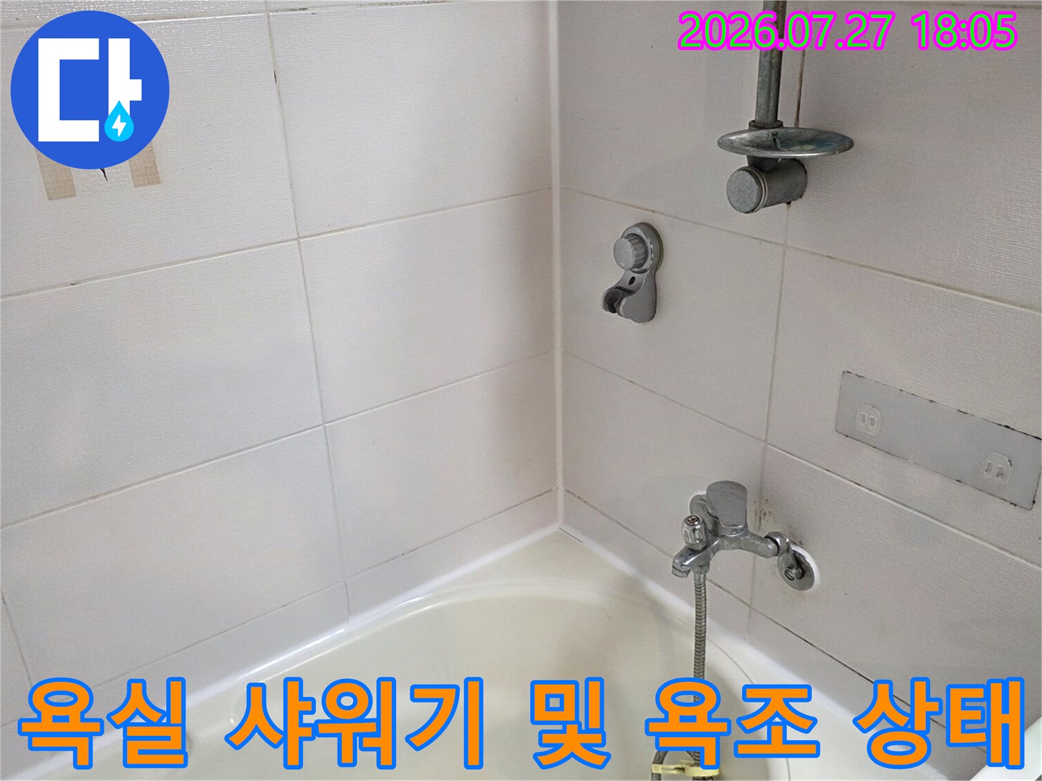 흰색 타일이 시공된 욕실 내부의-샤워 수전과-욕조 연결 부위 모습