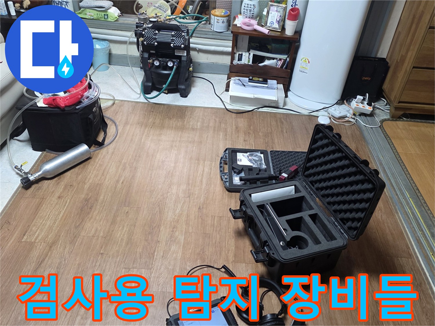 거실 바닥에 펼쳐진 전문적인 배관 누수 진단 측정 도구들