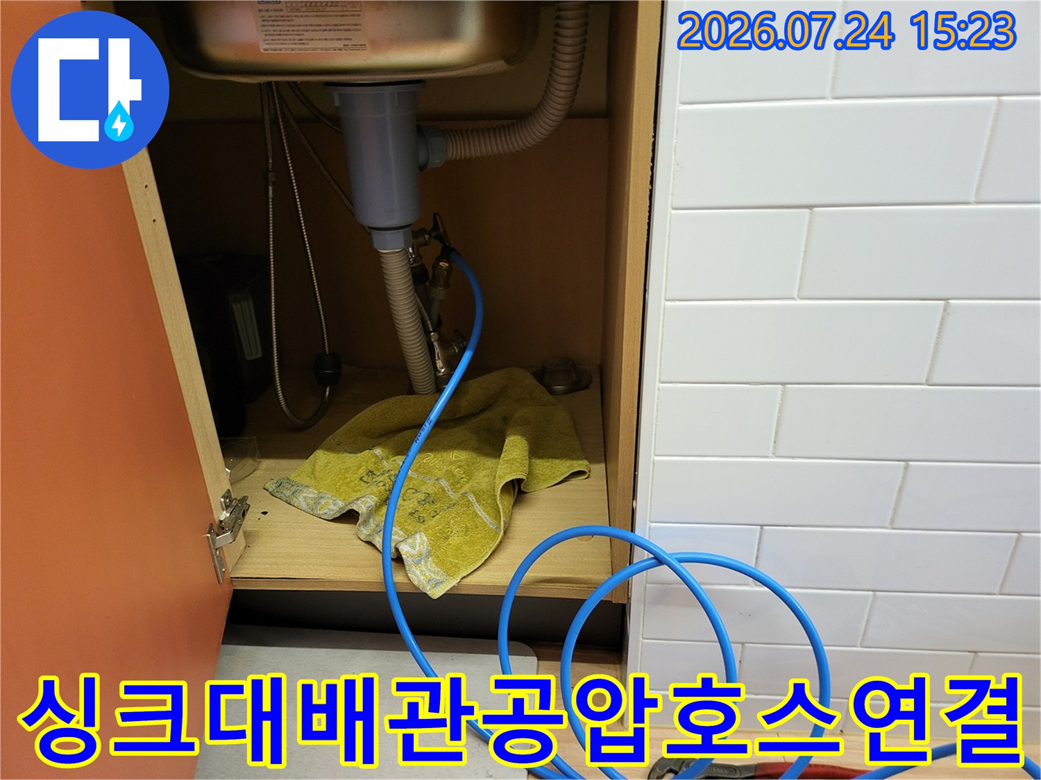 주방-싱크대-하부장-내부-배관에-파란색-검사용-호스가-연결된-상태