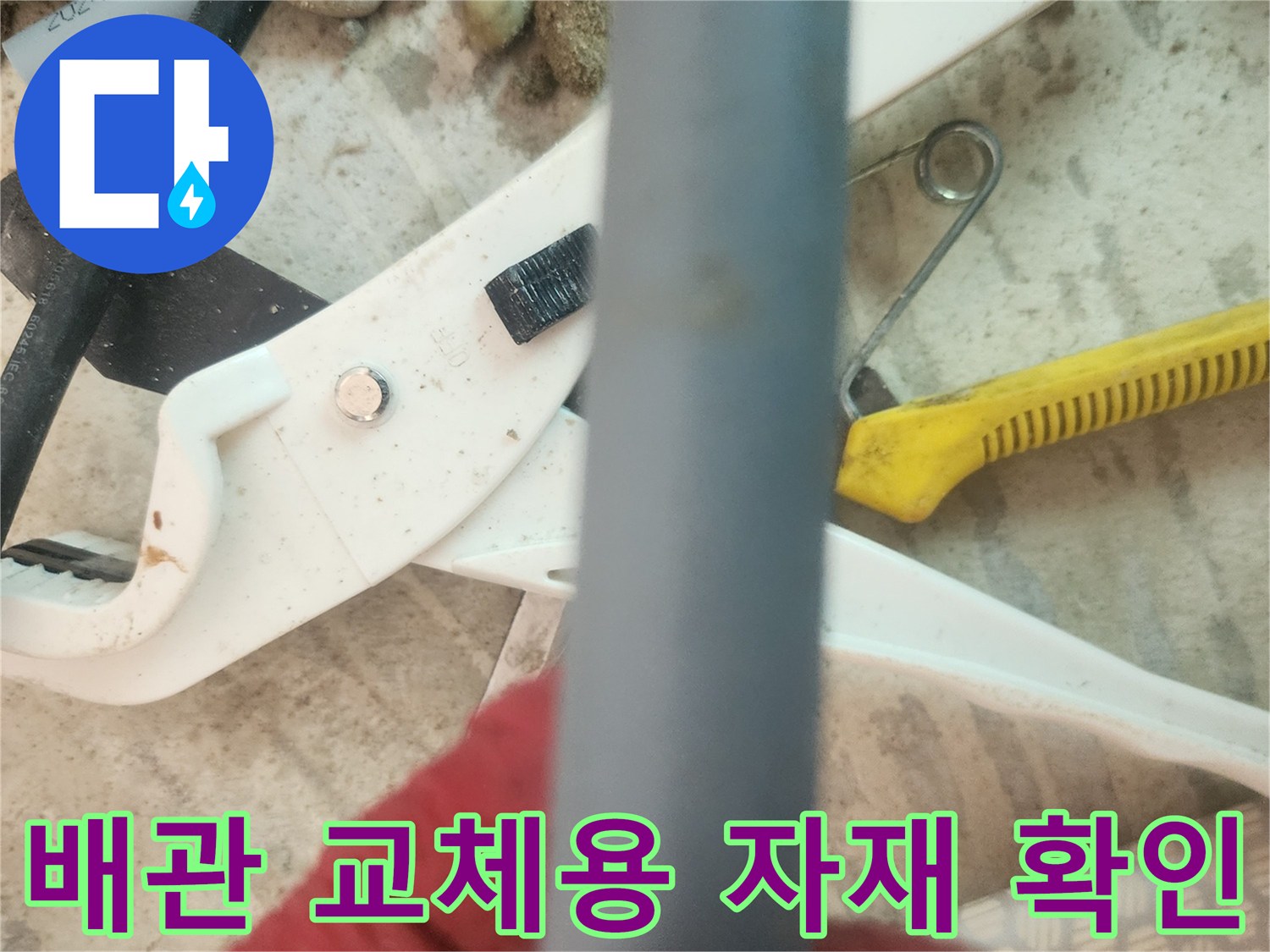 작업 중인 회색 배관과 공구들이 놓여 있는 모습입니다.