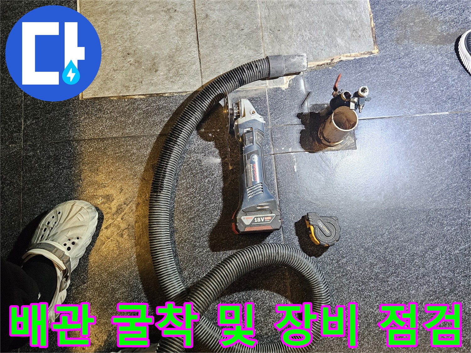 공사 현장 바닥에 놓인 전동 공구와 노출된 온수 배관