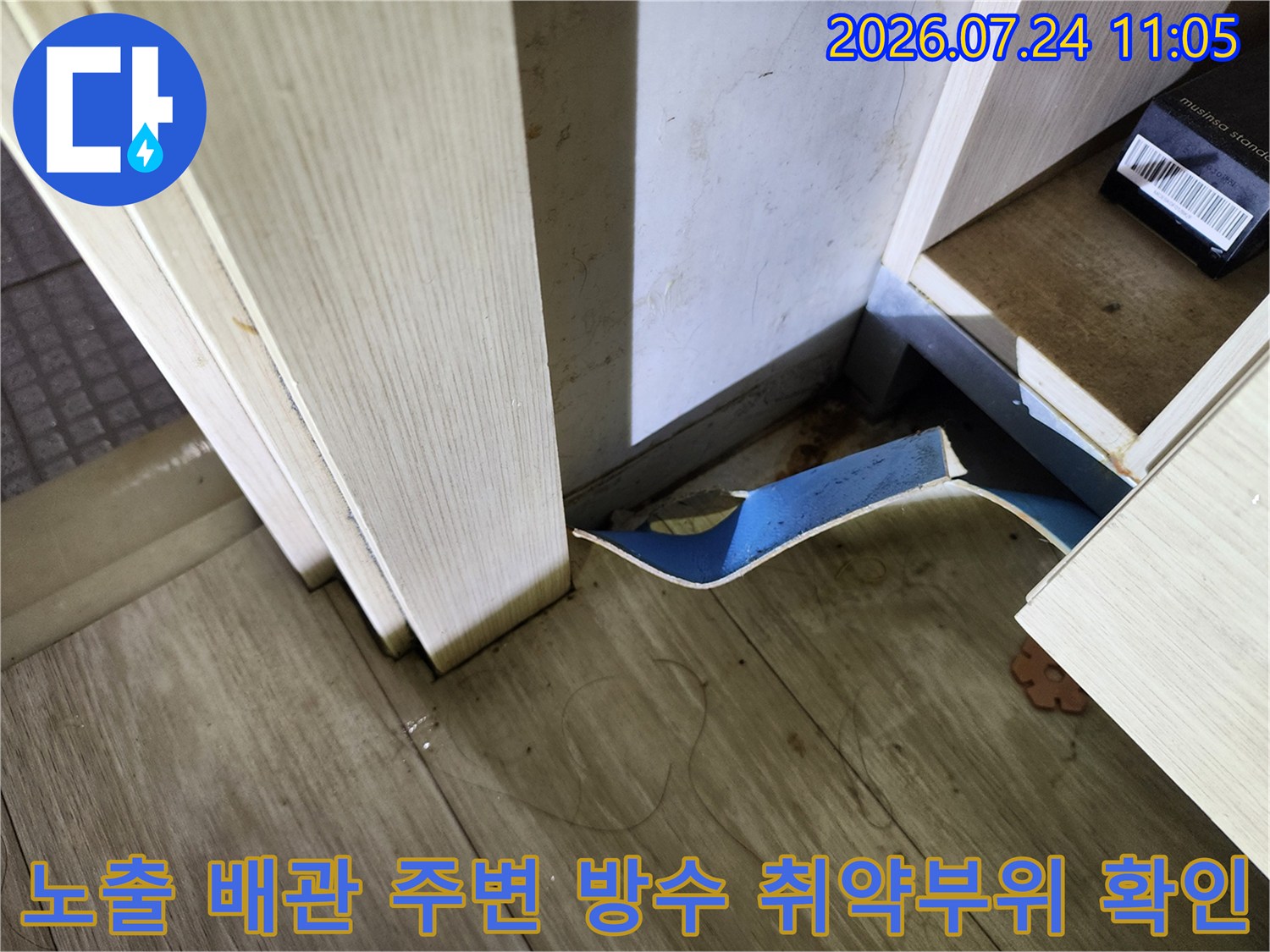 배관과 바닥 경계 지점에 노출된 파손 부위를 정밀하게 촬영한 사진
