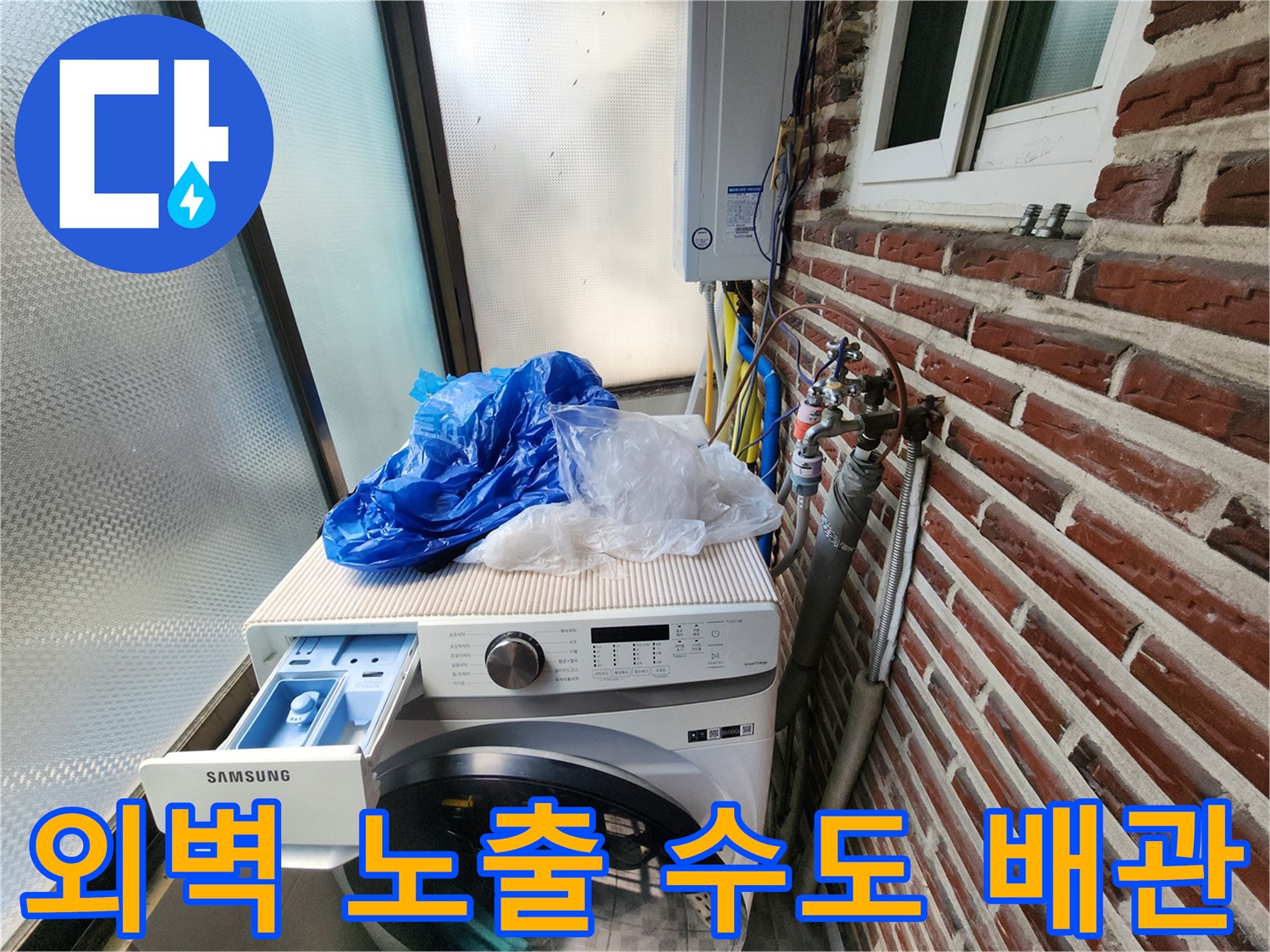벽돌 벽면에 설치된 외부 노출형 수도 계량기와 연결 배관
