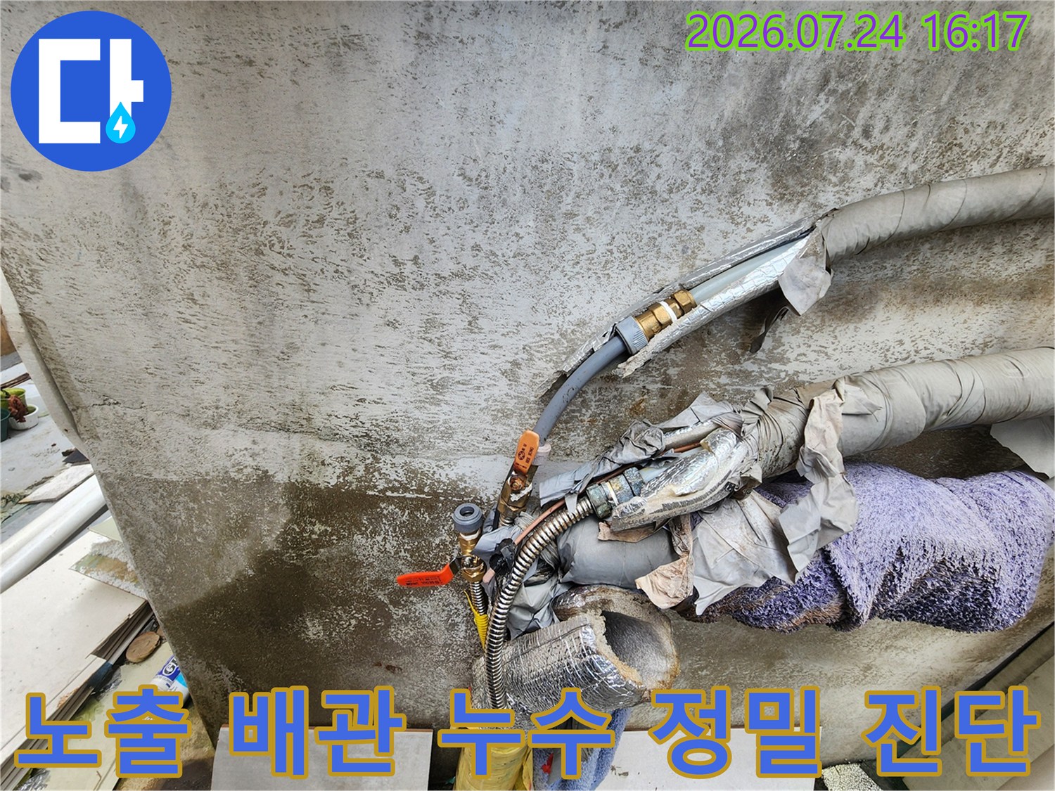 세탁실 내 노출된 다수의 수도 및 가스 배관을 꼼꼼하게 점검하는 기술자의 모습