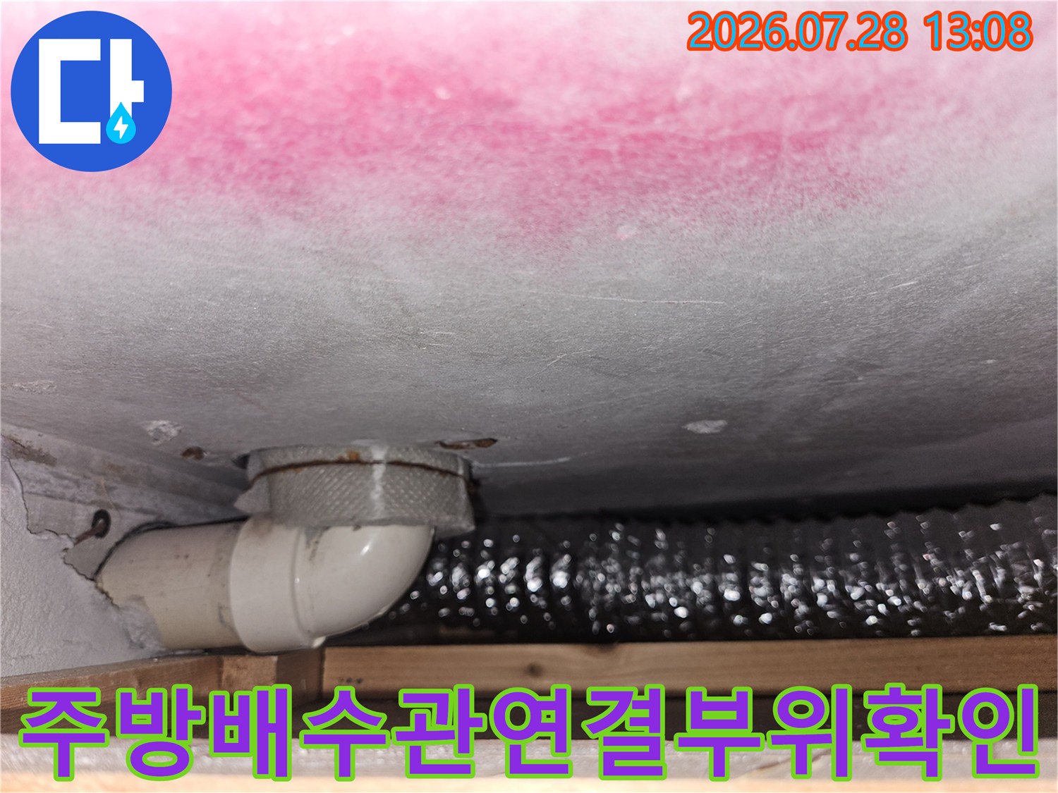 싱크대 하단 배수 트랩과 연결 부위의 누수 여부를 정밀하게 점검하는 모습