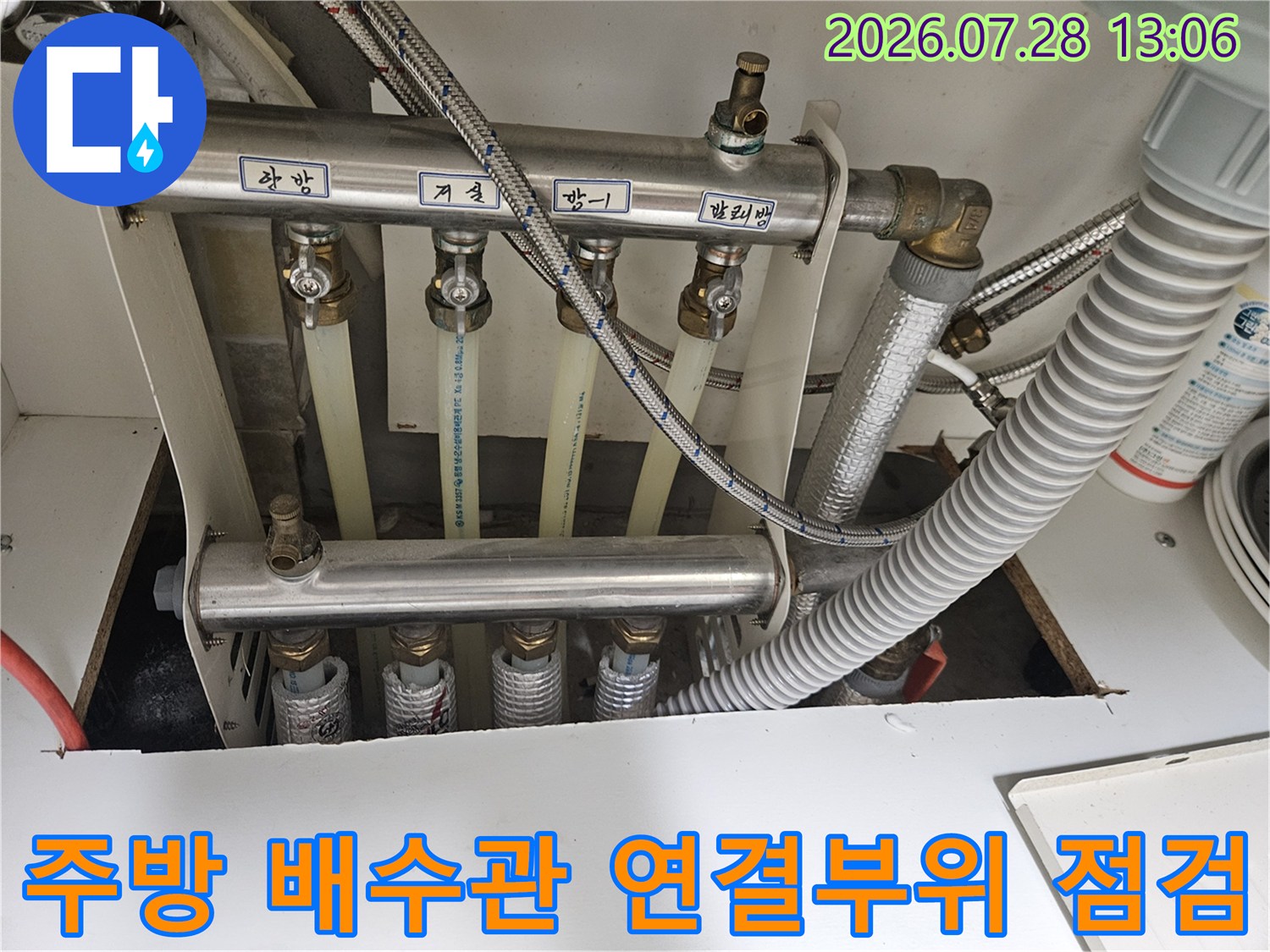 싱크대 하단에 위치한 주방 배수 배관 및 연결 부속의 점검 모습
