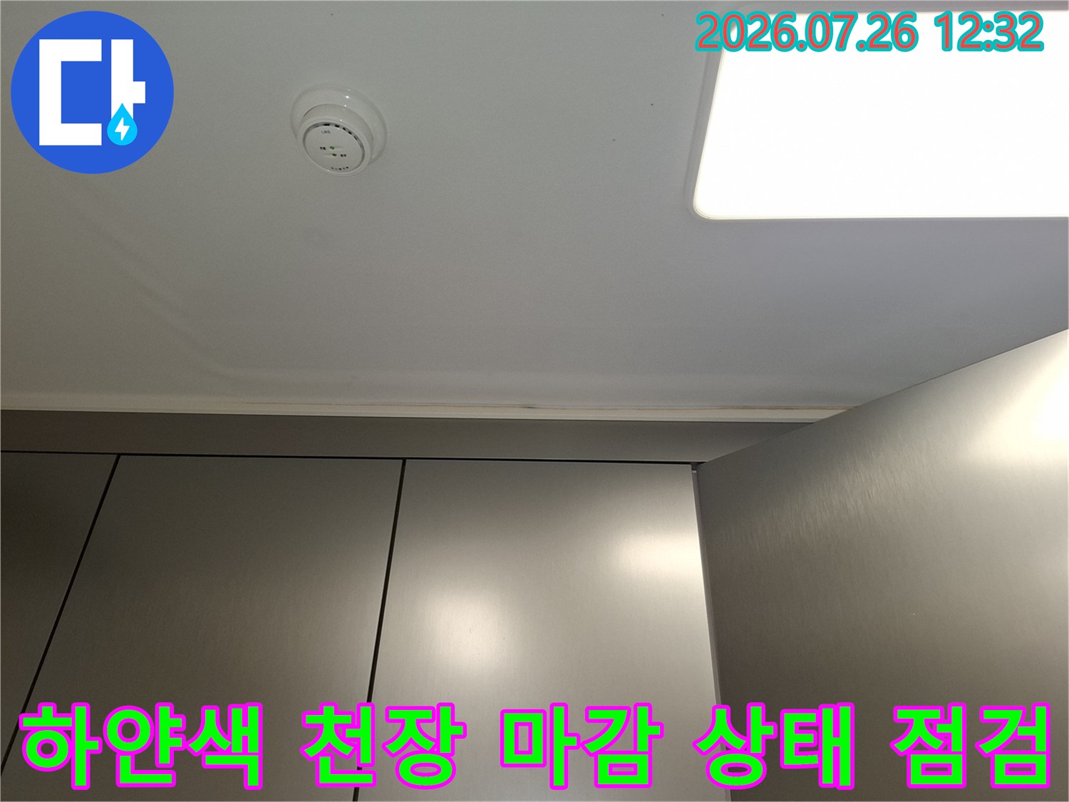 매끄러운 흰색 천장에 설치된 원형 감지기와 사각 조명 패널-전경
