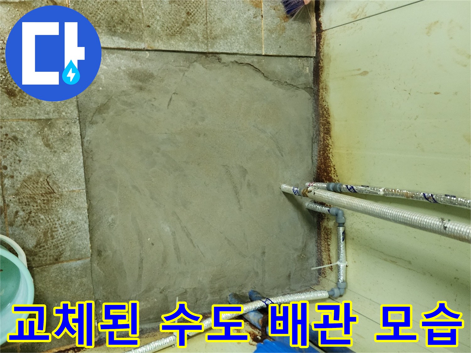 새로 교체되어 설치된 은색 배관과 미장 작업 부위