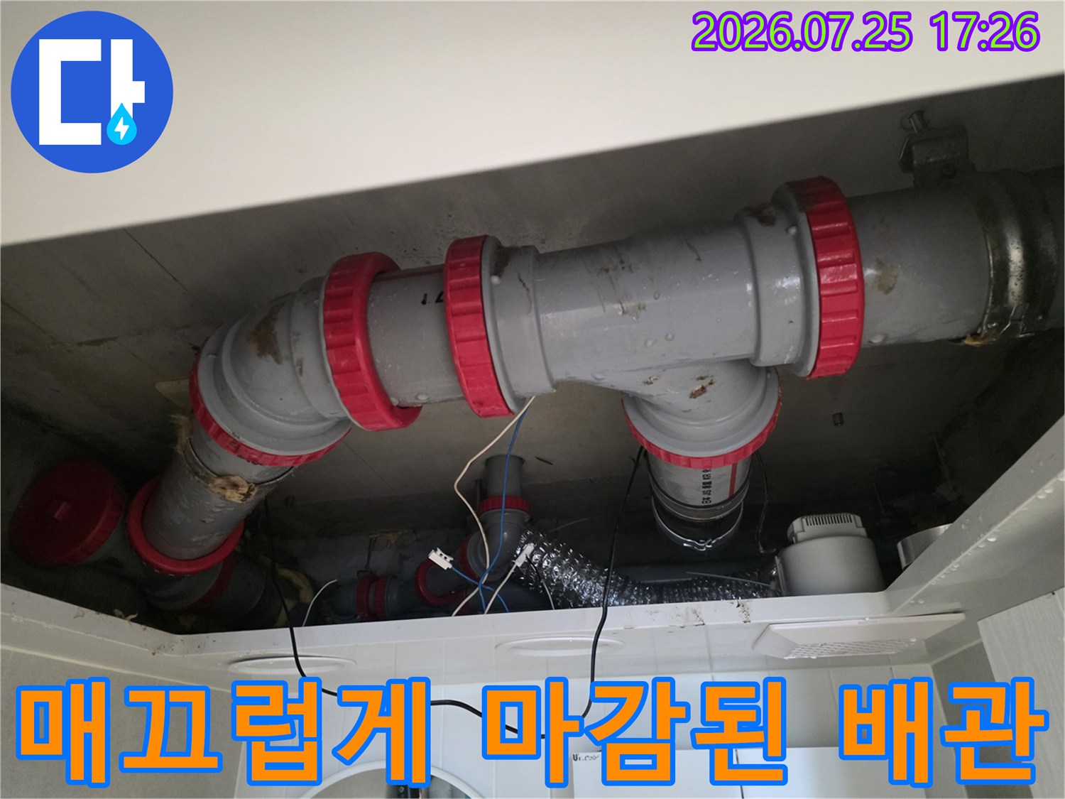 화장실 천장 내 노출된 배관의 견고한 연결부 수선 모습