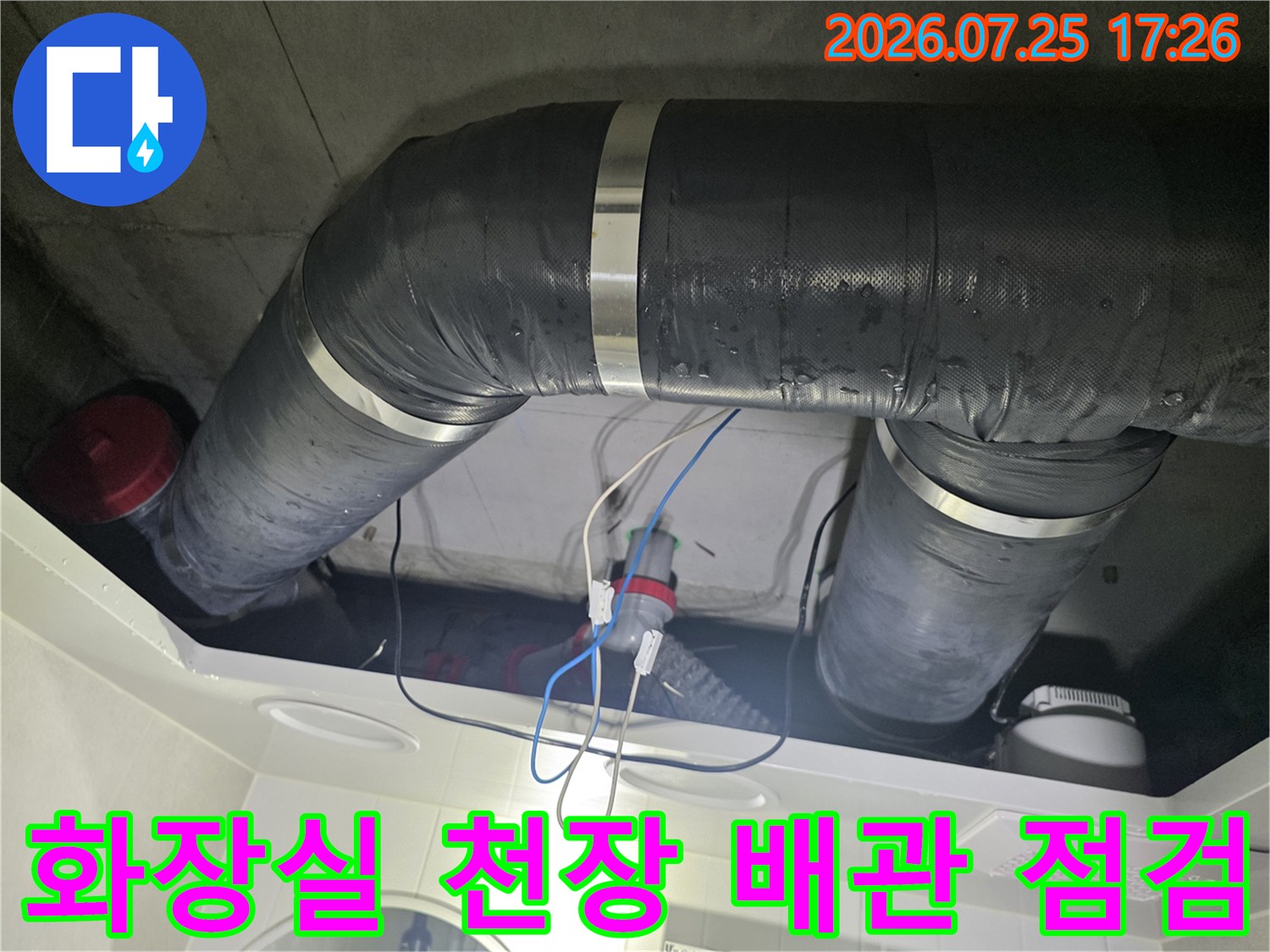 화장실 천장의 단열재로 감싸진 배관과 수선된 연결 부위 모습