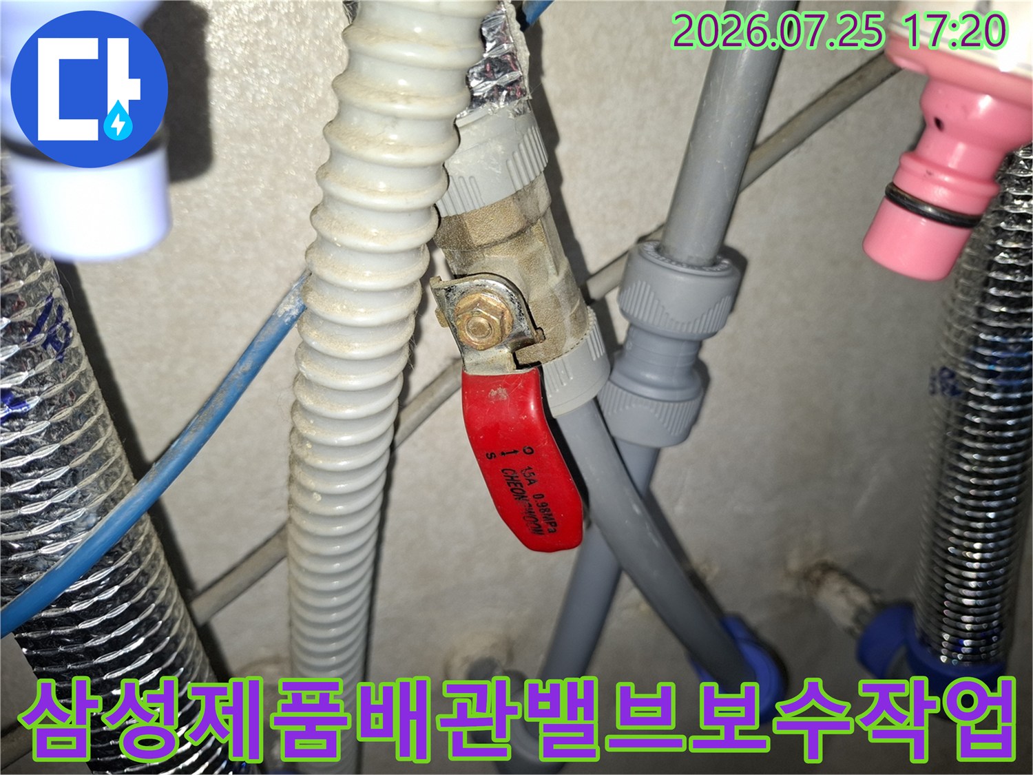 적색 밸브 핸들과 회색 배관 및 파란색 연결 부속이 보이는 상세 사진