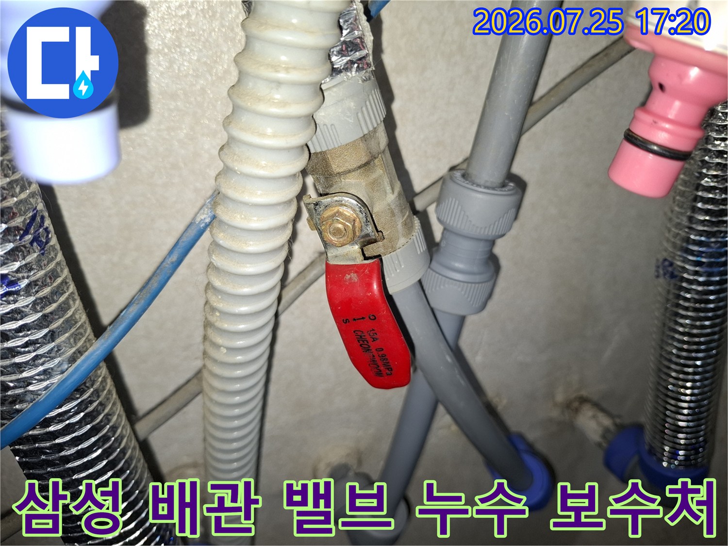 회색 플라스틱 배관과 빨간색 핸들 밸브가 맞물려 있는 연결 부위 사진