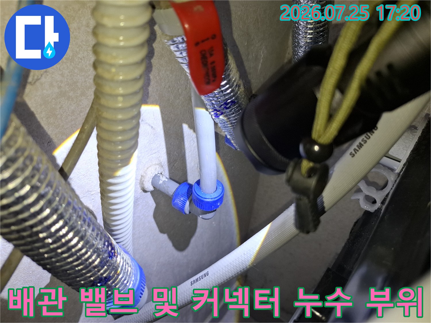 흰색 플라스틱 배관과 파란색 고정 너트-빨간색 조절 밸브가 설치된 배관 라인