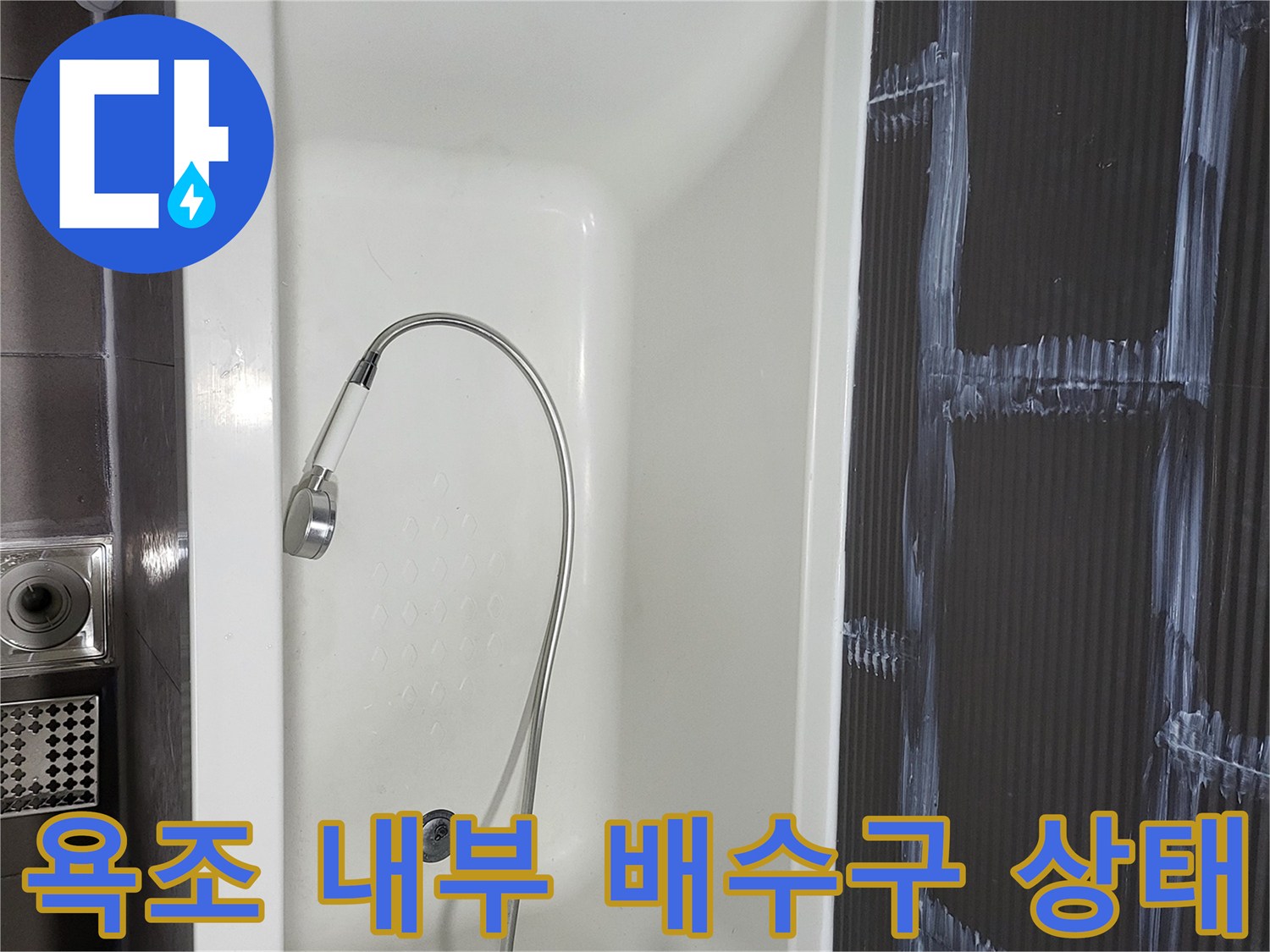 깨끗한 화이트톤 욕조-중앙의 배수구와 샤워 호스 모습