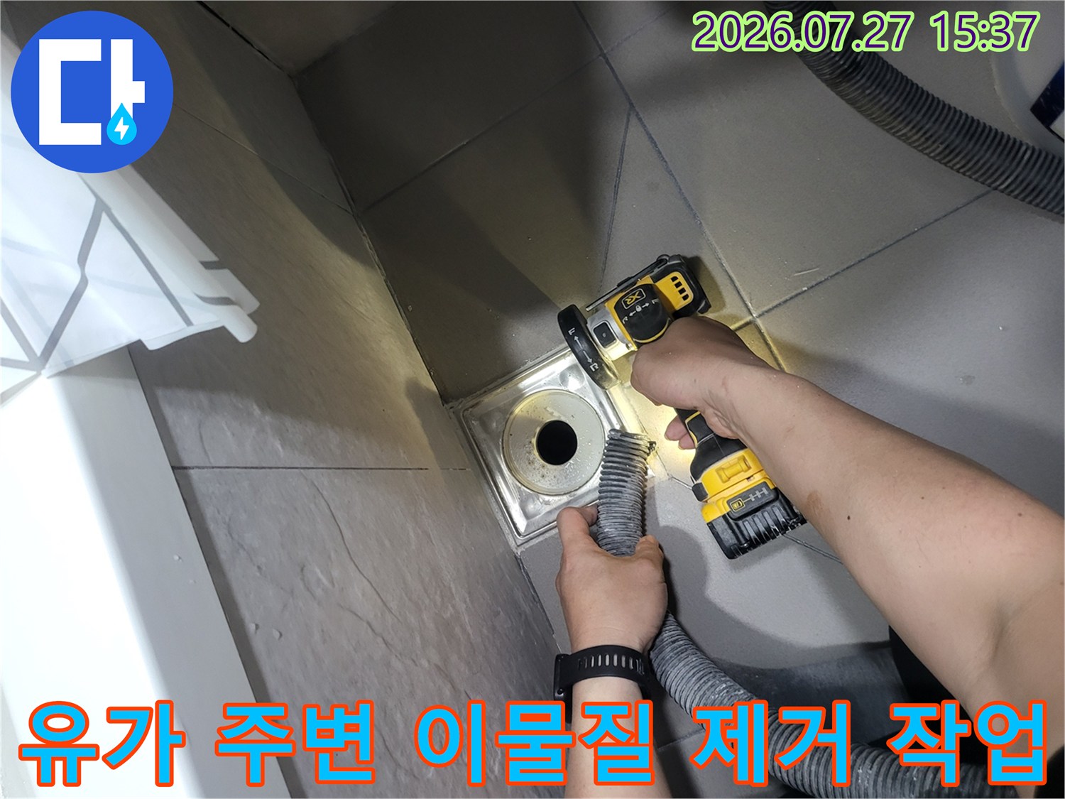 엔지니어가-전동 브러시를 사용하여-화장실 배수구의 오염된 부위를 청소하는 사진